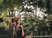 a woman in a black sari posing in a park