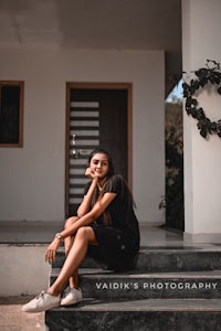 a young woman sitting on the steps of a house